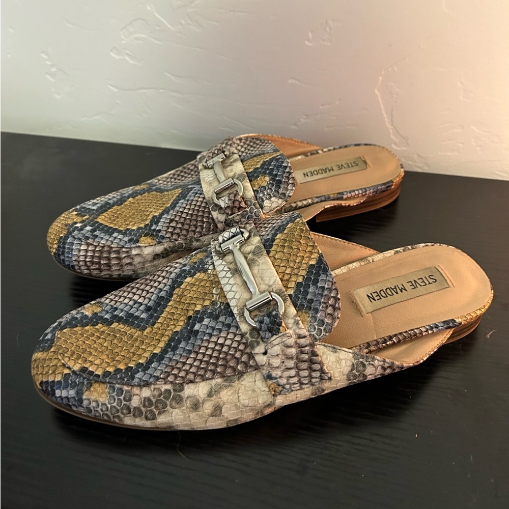 Steve Madden snake print slide on loafers with silver buckle.